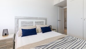 Une chambre à coucher avec un lit, des tables de chevet et une armoire.