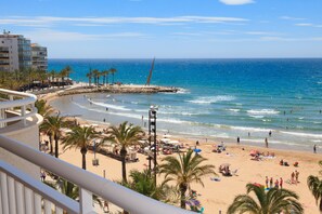 A beach with palm trees, a pier, and a view of the ocean. - Stunning views, 2-bedroom apartment, Salou centre UHC SANTILLANA 129 (Salou)