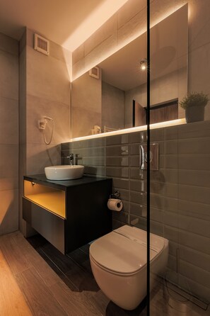 A modern bathroom with a sink, mirror, and toilet. - Nest Inn Mirror Apartment (Cluj-Napoca)