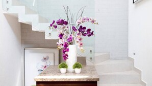 Una escalera con una pared blanca y una plataforma de madera al final.
