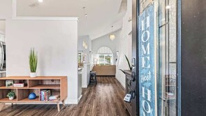 Ein modernes Interieur mit Holzboden, Bücherregal und Küchenzeile.