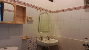 A bathroom with a toilet, a sink, a mirror, and a shower. - OYO 93706 Penginapan Syariah Hj. Kenan (Koto Tinggi)