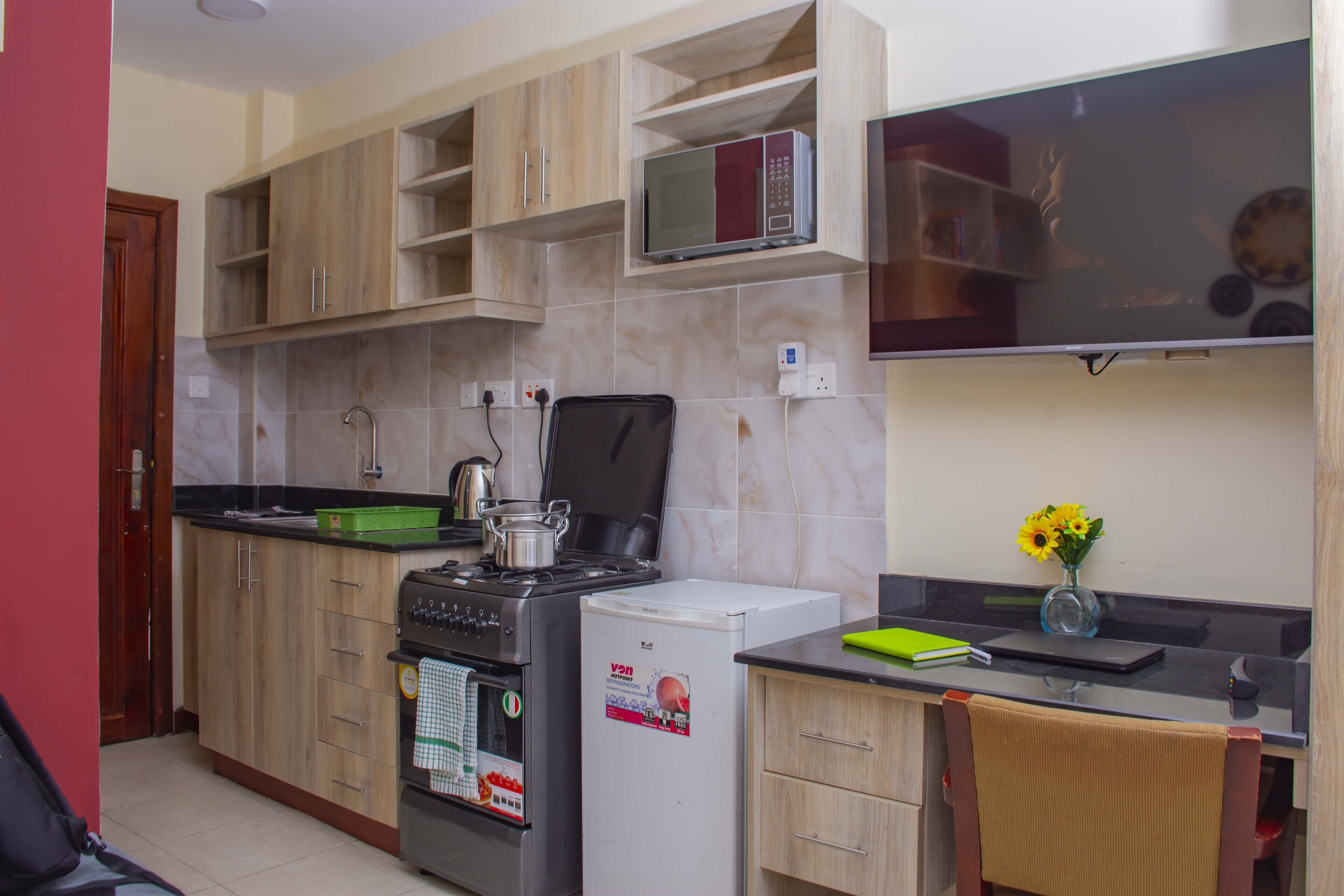 A kitchen with wooden cabinets, a microwave, a stove, and a refrigerator.