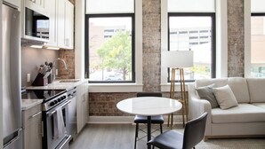 Une cuisine moderne avec un coin repas, un canapé et une lampe.
