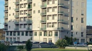 A multi-story residential building with balconies, a parking area, and a grassy foreground. - Palermonamour Art Gallery Suite (Palermo)
