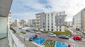 Um moderno conjunto de apartamentos com vários edifícios, área de estacionamento com carros e céu claro.