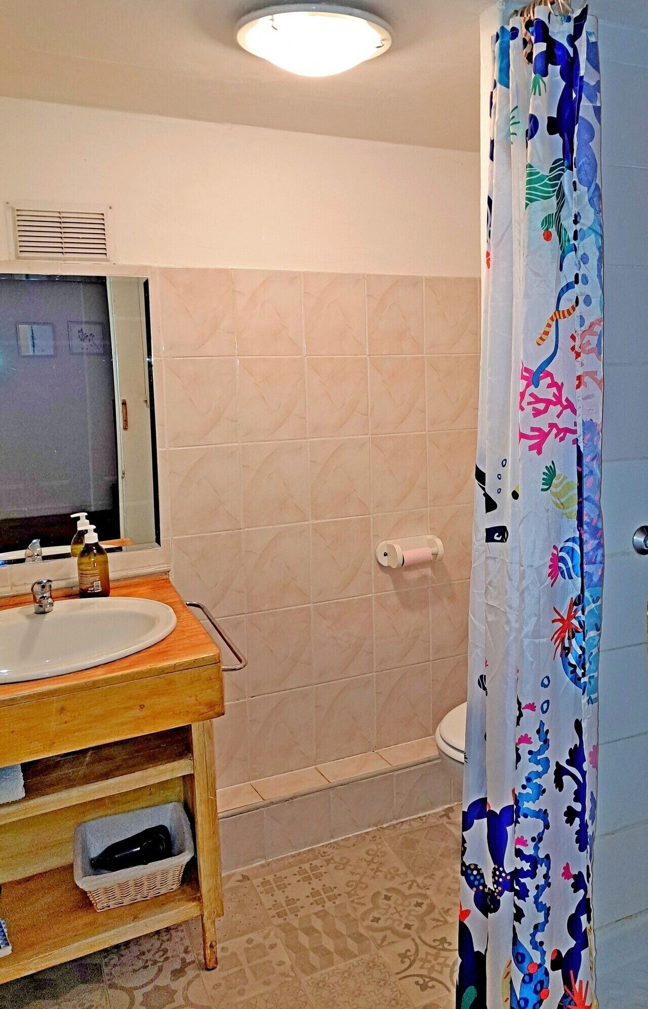 Un bagno con lavandino, specchio e water.