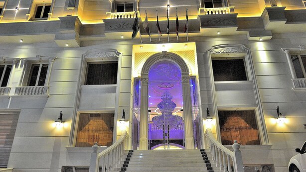Un majestuoso acceso con un arco central, varias arbotantes y una escalera que conduce a la entrada principal.