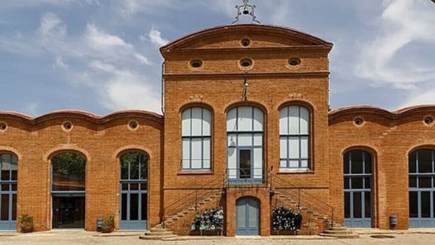 A large brick building with a central staircase, arched windows, and a symmetrical facade. - Aparta 4 Habitaciones Terrassa Centro, Parking (Terrassa)