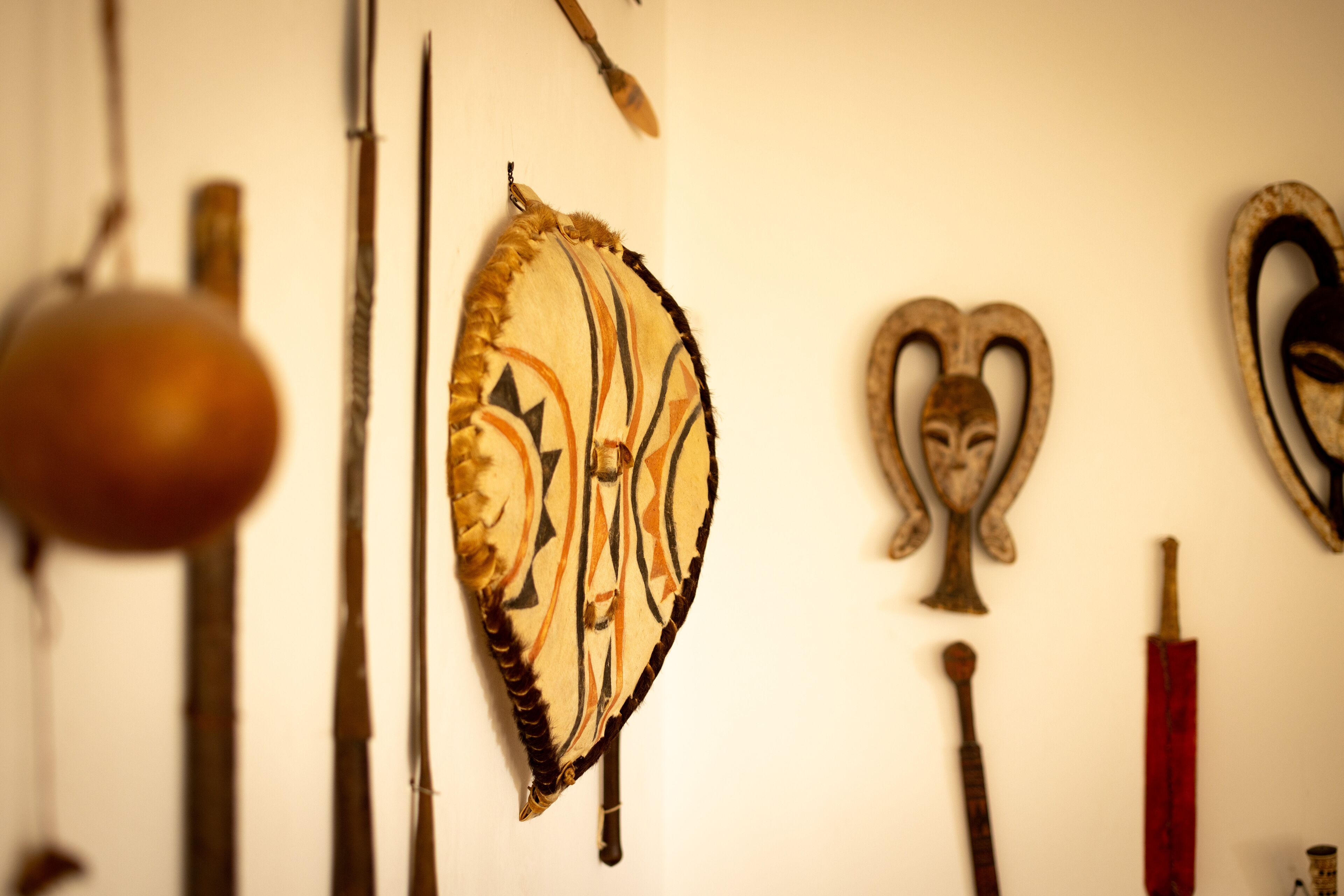 A wall with various historical artifacts including a shield, a sword, and a mask.