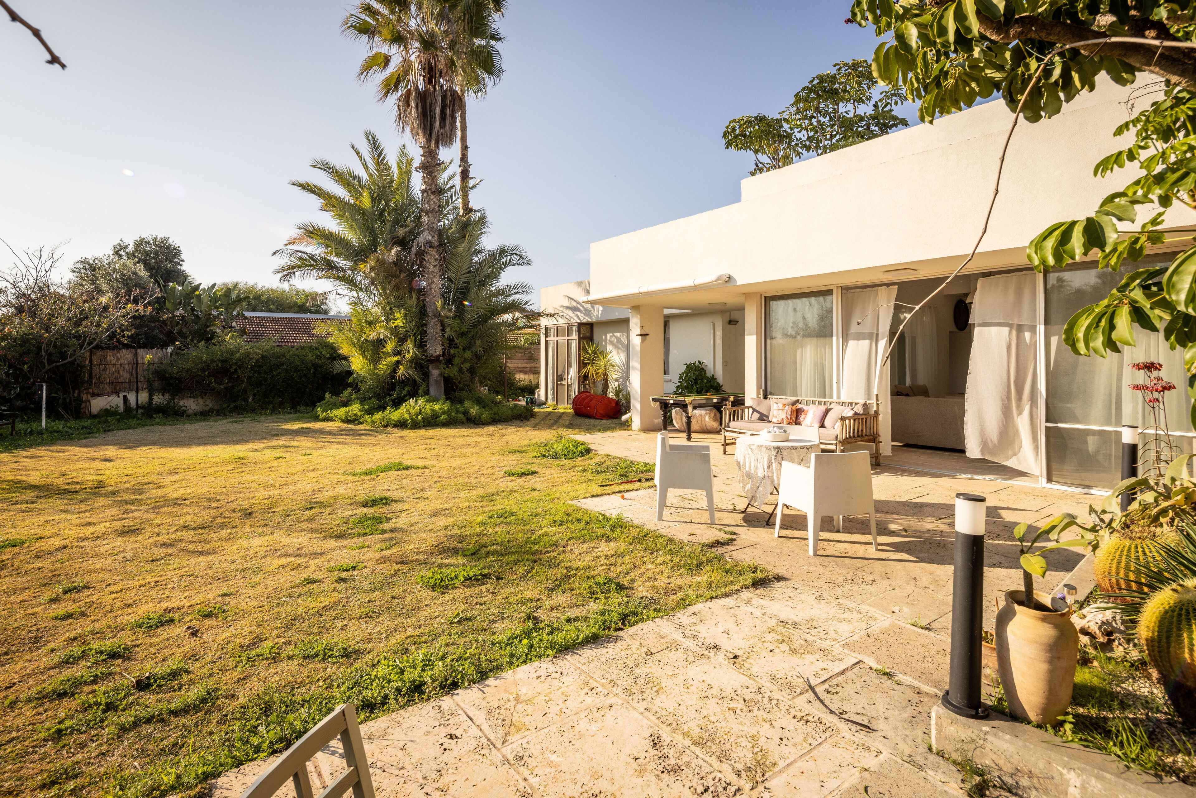 A modern house with a patio area featuring outdoor furniture and a garden.