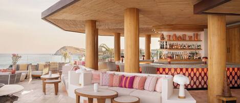 Eine Strandlounge mit Bar, Sitzgelegenheiten und Meerblick.