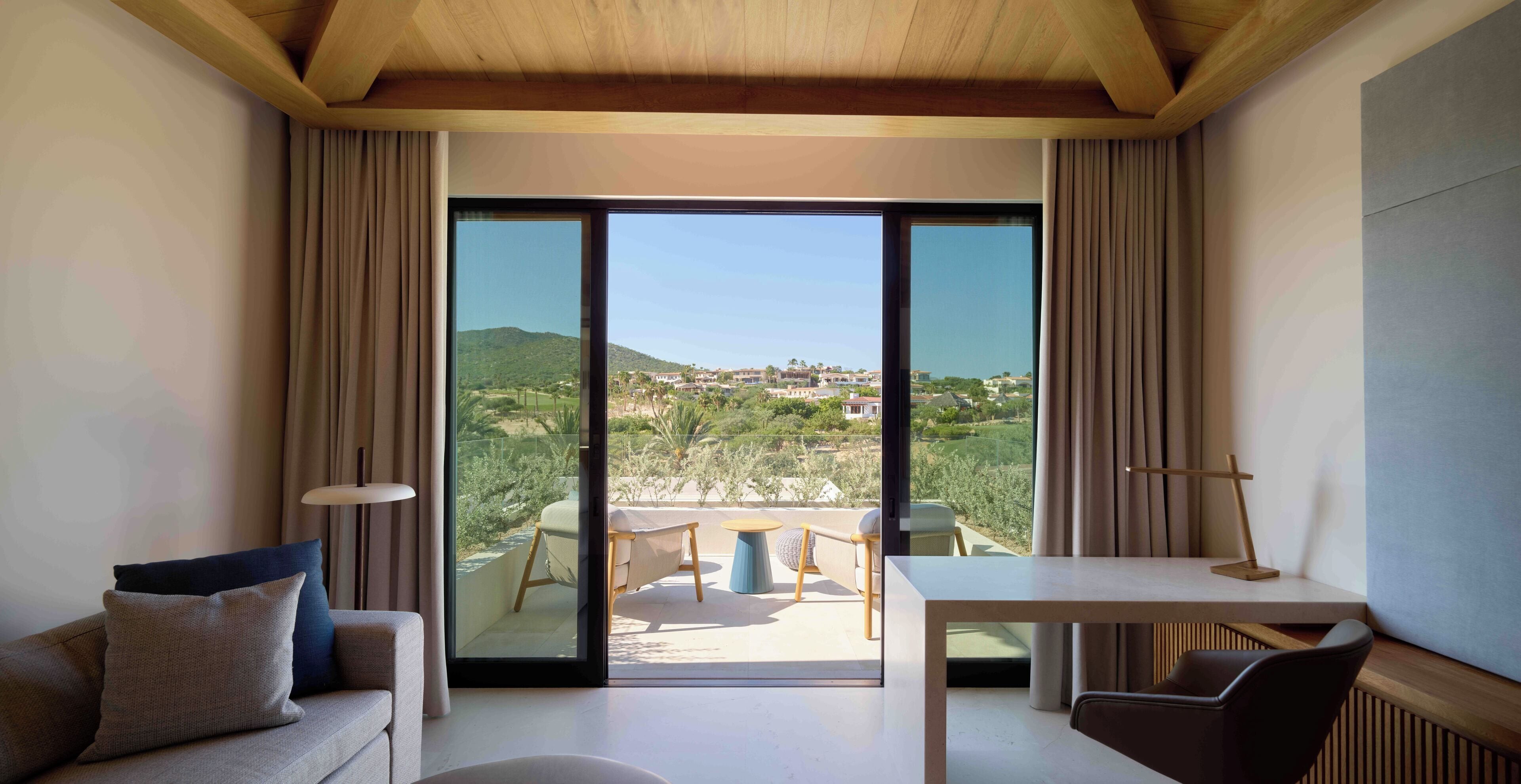 Een moderne kamer met een grote schuifglazen deur die uitkomt op een terras.