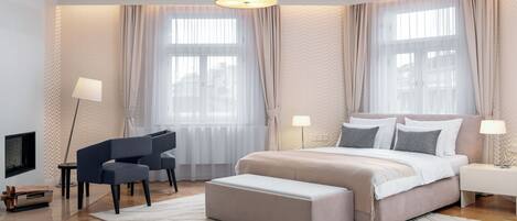 A modern bedroom with a bed, bedside tables, a desk, and a chair.