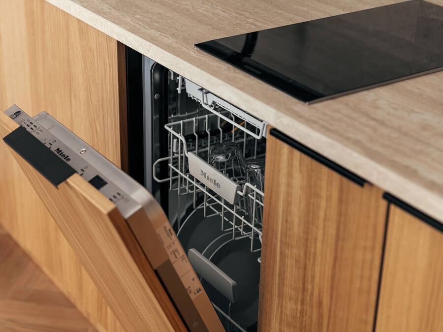 A kitchen with a dishwasher, wooden cabinets, and a countertop.