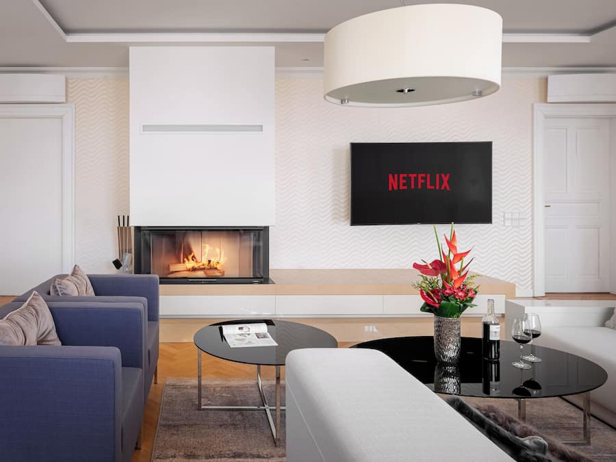 Uma sala de estar moderna com lareira, uma televisão de tela plana acima e um conjunto de sofás.