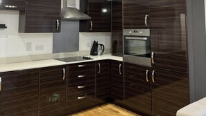 Een moderne keuken met donkerhouten kastjes, roestvrijstalen apparatuur en een centraal eiland.
