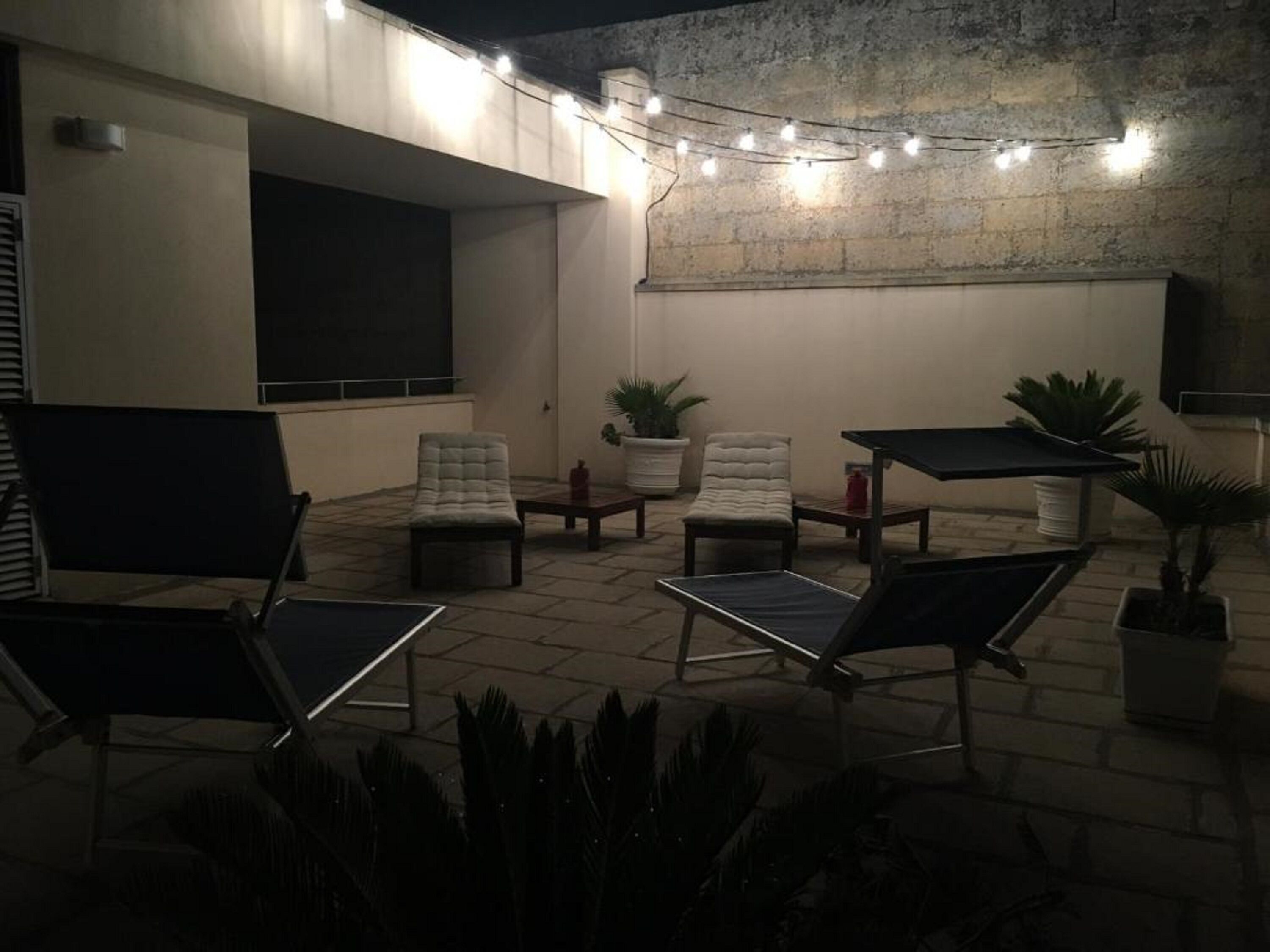 An outdoor patio area with seating, a table, and string lights.