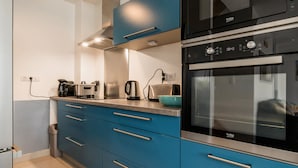 Une cuisine moderne avec des meubles bleus, un four double et une machine à café.