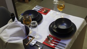 A table set for dining with black plates, silverware, and glasses of wine. - "Dione" Luxury Business Suite in the Heart of Athens (Athina)