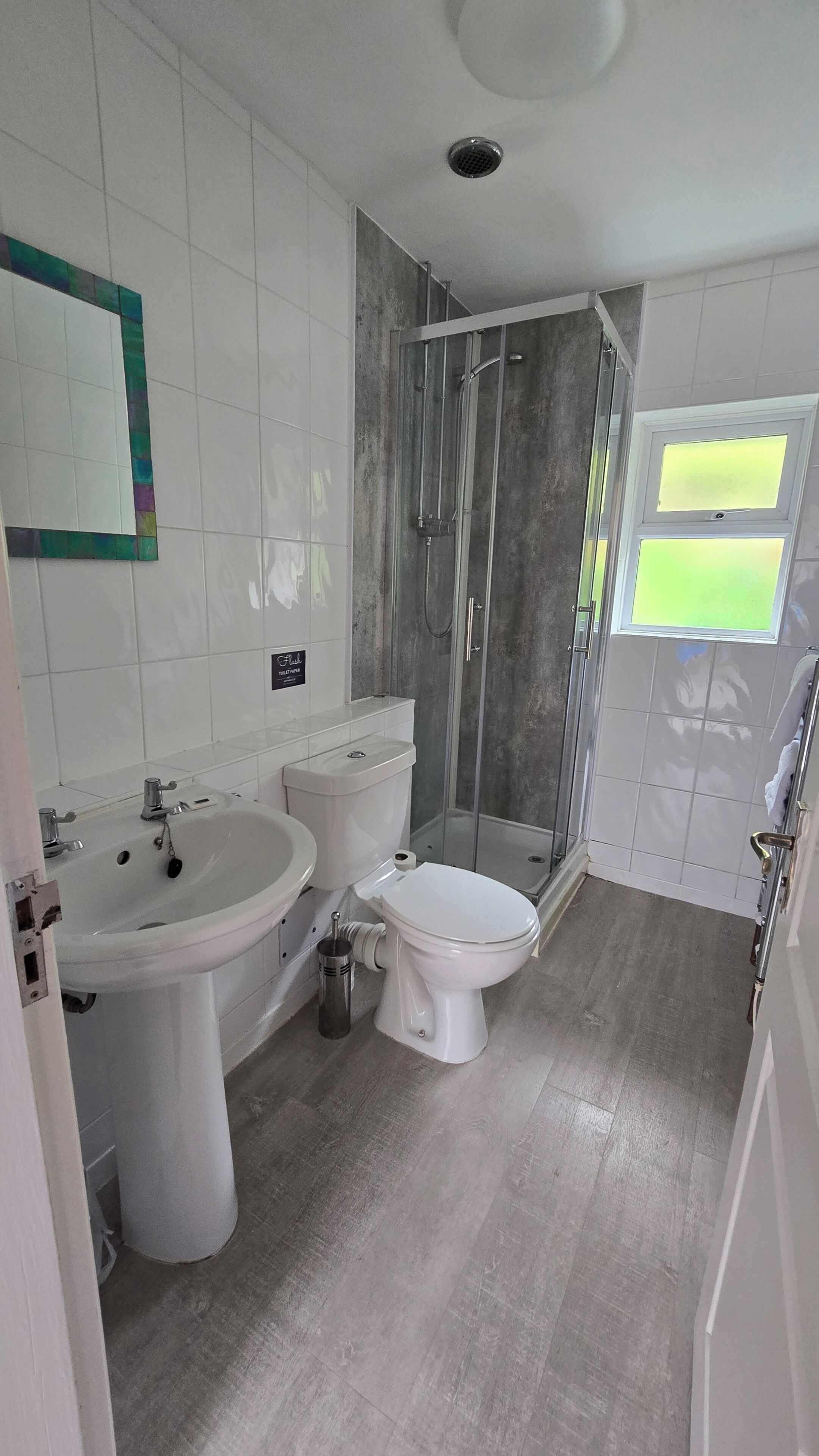 A bathroom with a shower, toilet, and sink.