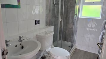 A bathroom with a shower, toilet, and sink.