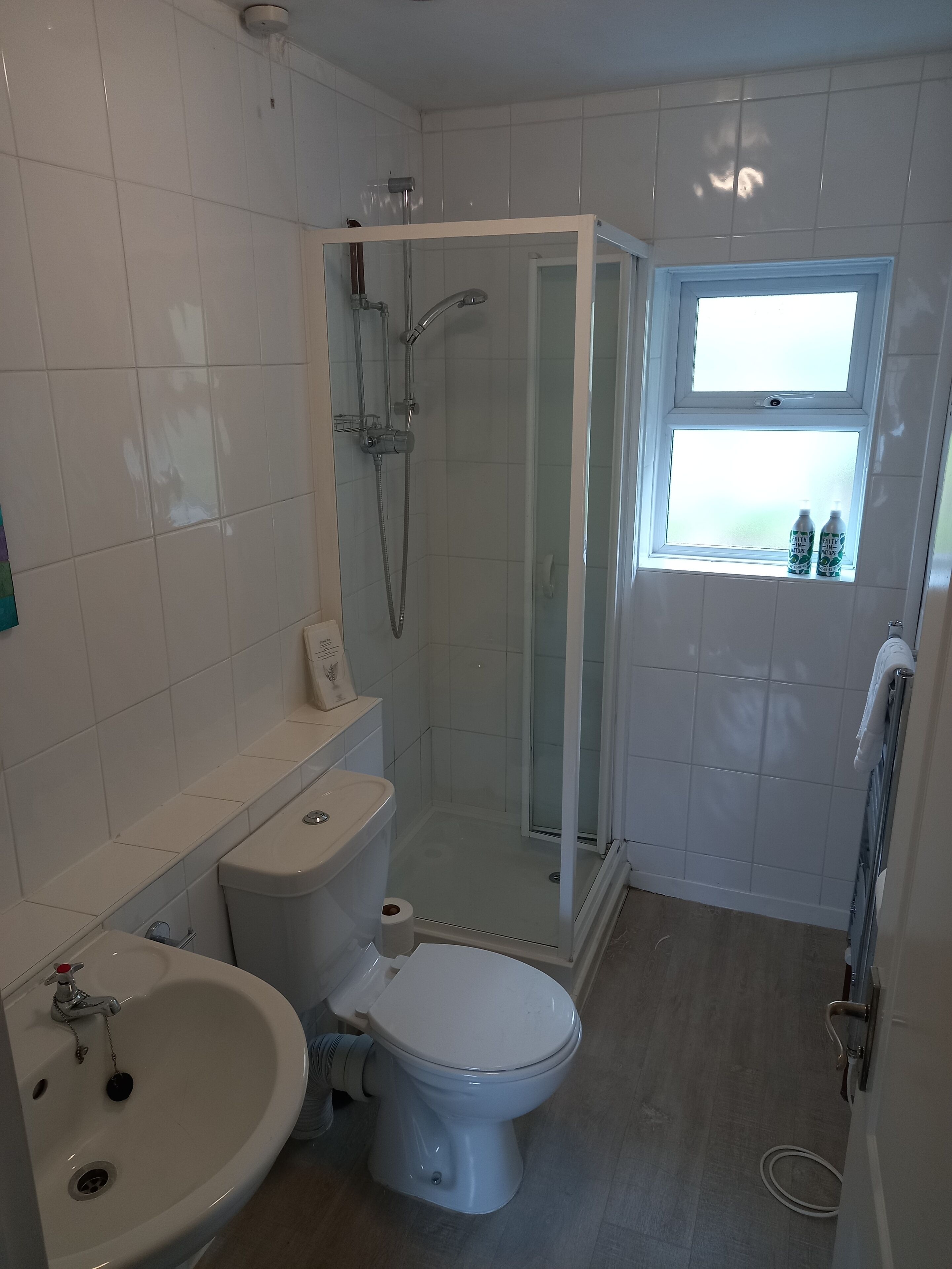 A bathroom with a toilet, sink, and shower.