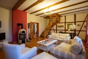 Un salon chaleureux avec une cheminée, un escalier et un ensemble de canapés.