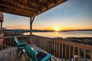 Duck under the covered deck as the sky turns gold and let the sunset over the marsh close out your day. - Soundfront sunset decks · Pool · Game room (North Topsail Beach)