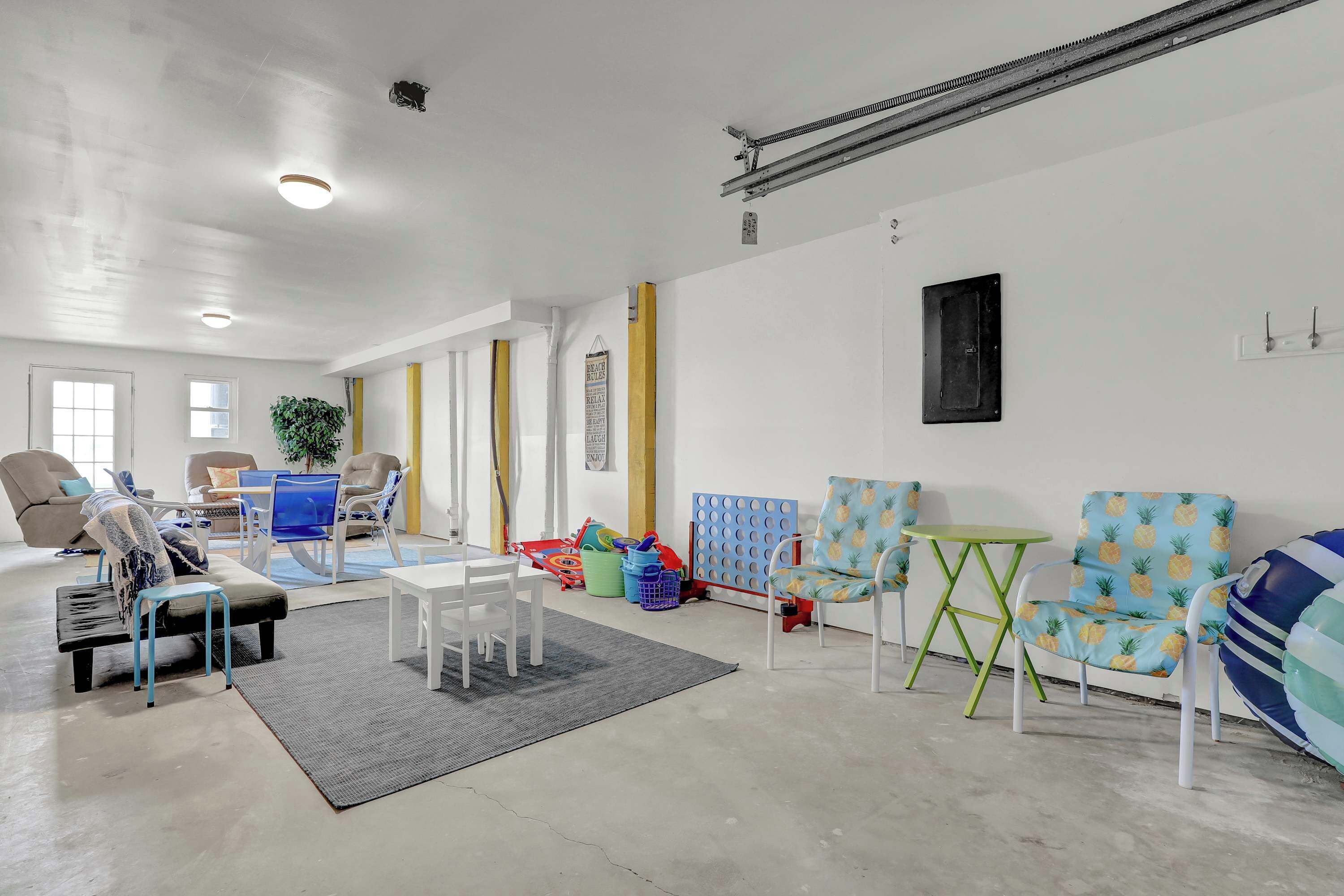 Amplia sala de estar con sofá, sillas, una mesa de comedor y una pequeña cocina.