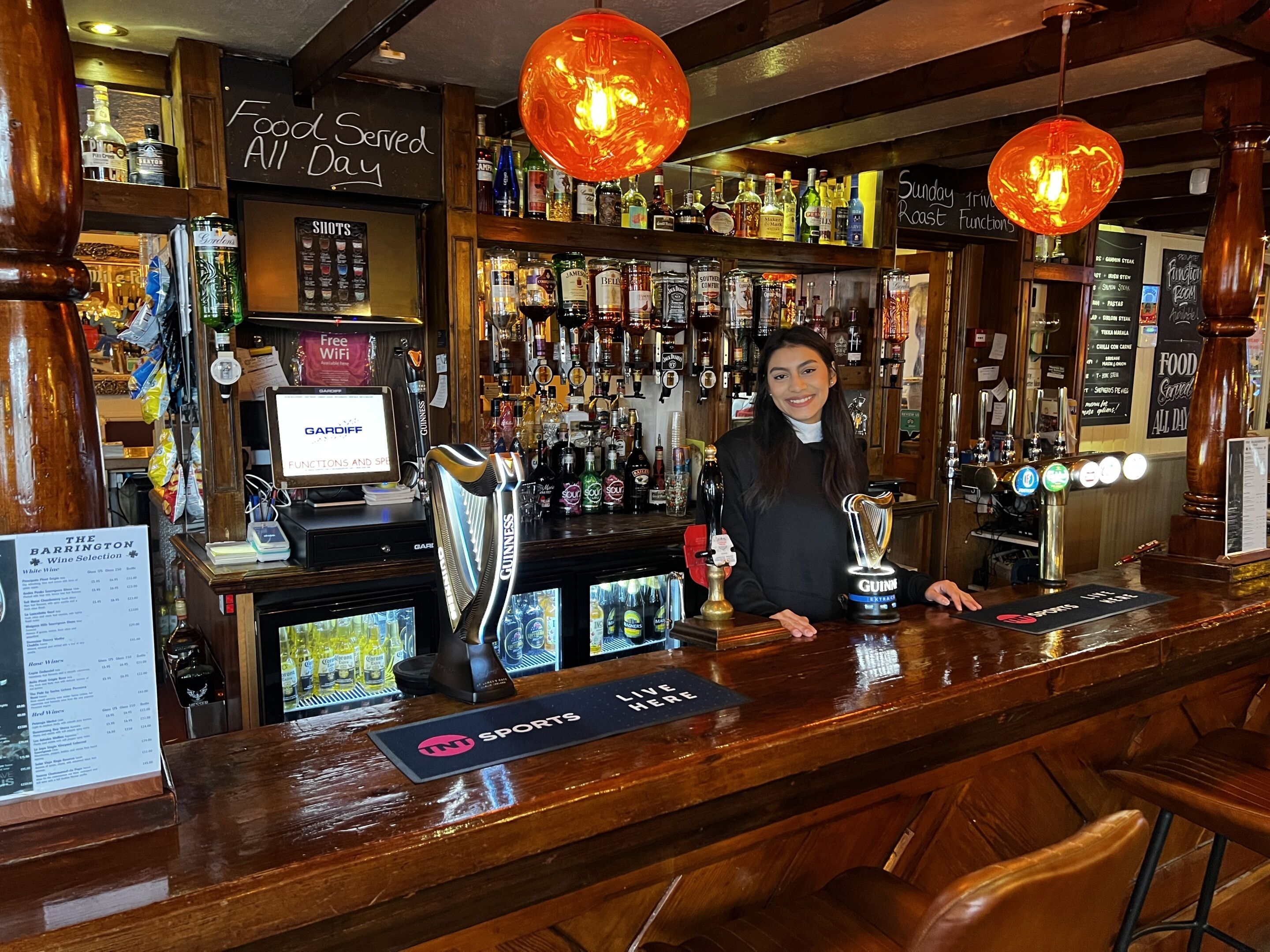 A bar with a variety of liquor bottles, a sign indicating free WiFi, and a Guinness beer tap.