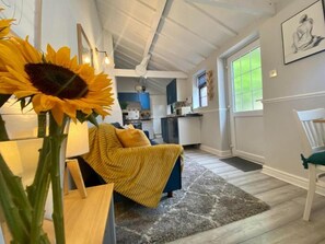 A cozy living room with a sofa, a coffee table, and a large sunflower.