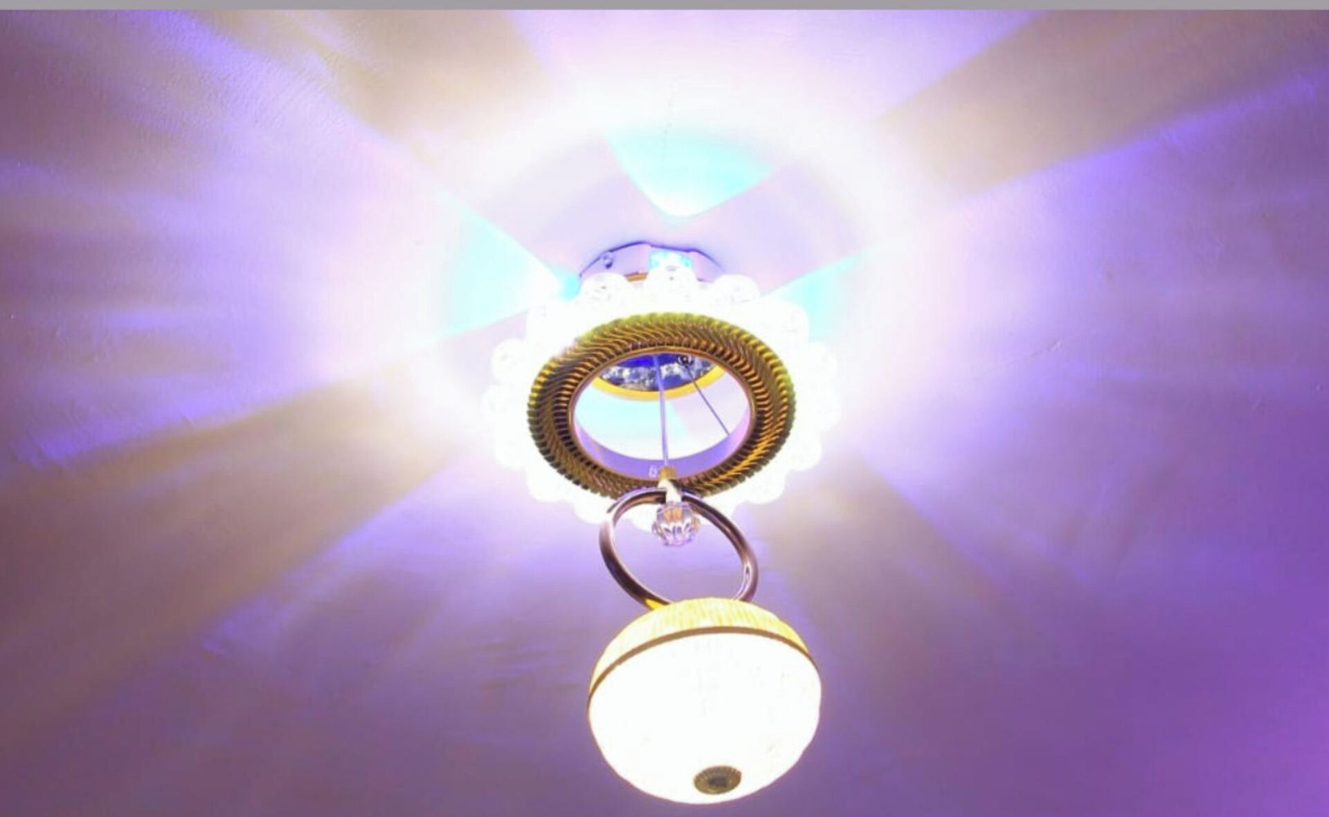 A ceiling light fixture with a circular design and a hanging pendant light.