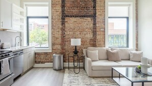 Eine moderne Küche mit Backsteinwand, einer Couch und einer Lampe.