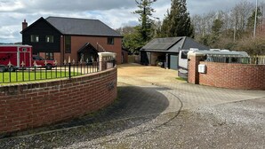 A brick building with a garage and a covered area, possibly a barn or workshop. - Romantic King Bed Countryside Couples Cabin (Salisbury)