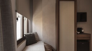 A compact room with a window, a sofa, a small cabinet, and a television. - Copal Simple Staying (Chania)