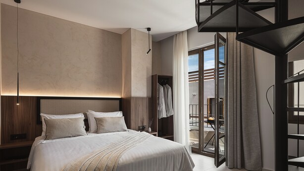 A modern bedroom with a large bed, a wooden headboard, and a built-in wardrobe. - Copal Simple Staying (Chania)