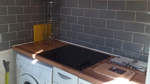 Une cuisine compacte équipée d’un lave-linge, d’une cuisinière et d’un four à micro-ondes.