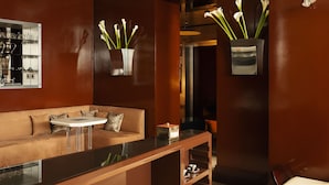 A modern kitchen with a built-in island, a seating area with a sofa and a small table, and decorative vases with flowers.