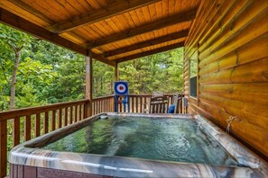 A wooden deck with a hot tub, a target, and chairs. - Amazing Mountain View, Hot Tub, Game Room! (Sevierville)