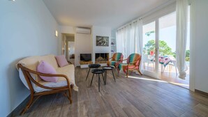 Amplia sala de estar con sofá, sillones, televisor y chimenea.