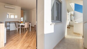 A modern kitchen with a dining area, a staircase, and a view of the outside. - 3726 Appartamento Nicole by Barbarhouse (Porto Cesareo)