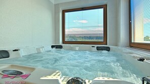 Un bain à remous avec vue sur l’extérieur, une balance et une serviette.