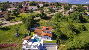 A residential area with houses, a swimming pool, and a large tree. - Villa Gloria Vita by Villas Guide (Brtonigla)