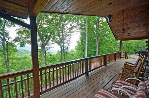 Relax on the sheltered deck, surrounded by a serene forest landscape.