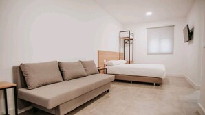 A bedroom with a sofa, a bed, a bedside table, and a wardrobe. - Polorooms Vara (Zaratan)