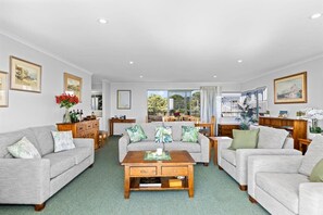 A spacious living room with a sofa set, a coffee table, and a view of the outdoors.