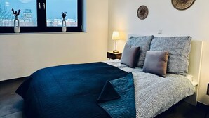 Ein Schlafzimmer mit Bett, Nachttisch, Lampe und Wanddekoration.