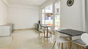 A modern kitchen with a dining area, a refrigerator, and a window with a view of the outside. - AVS PRIME (Barasat)