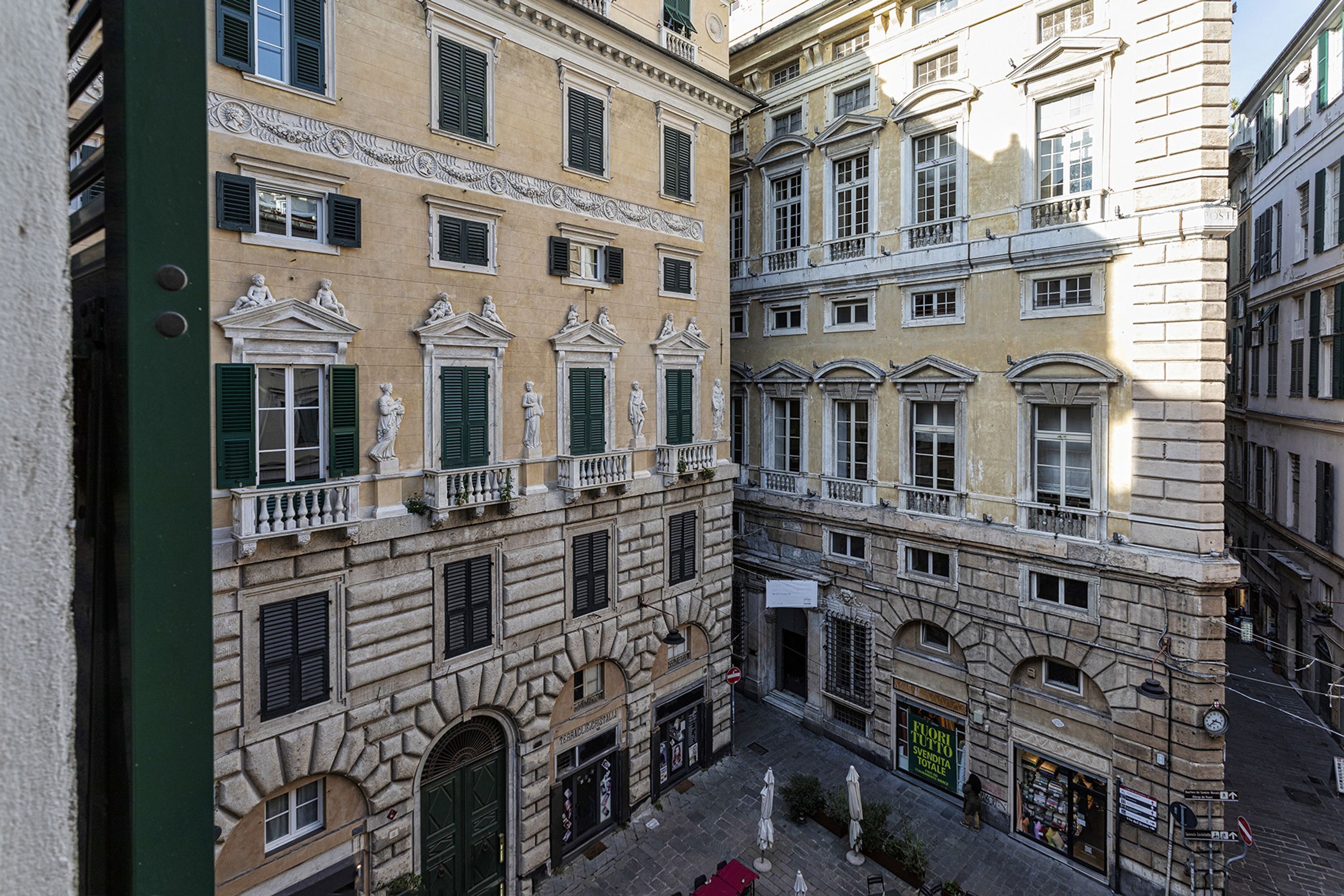 Ein Innenhof mit Gebäuden im klassischen Stil, darunter Statuen und kunstvolle Balkone.
